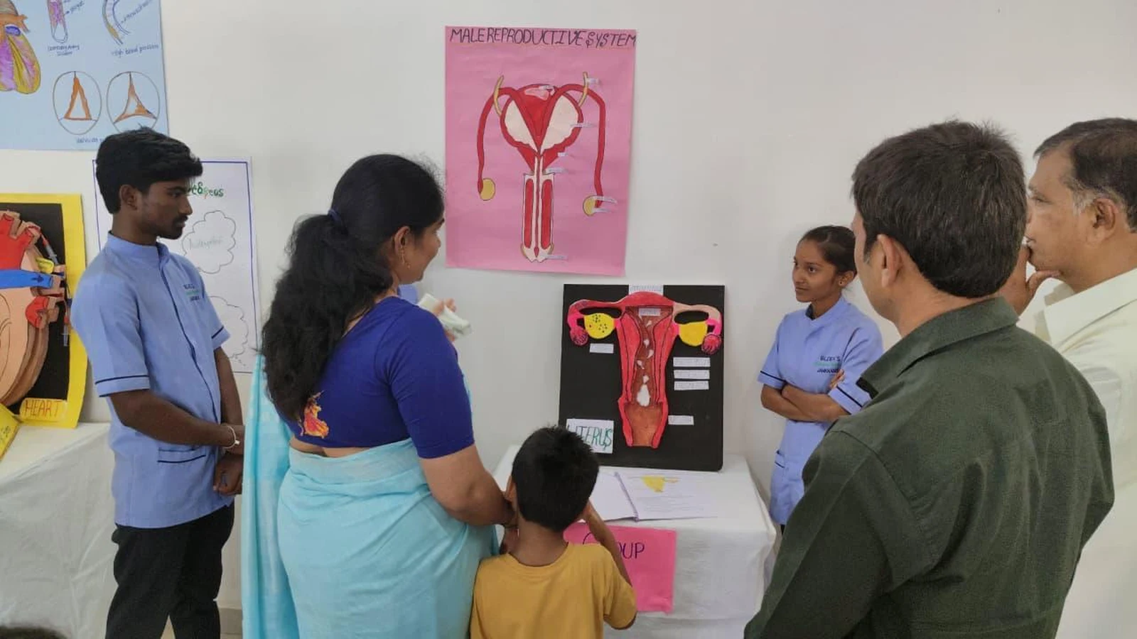 Faculty examining Group VIII Female and Male Reproductive System model at Anatomy Physiology Model Exhibition 2026 – BLDEA College of Nursing Jamkhandi