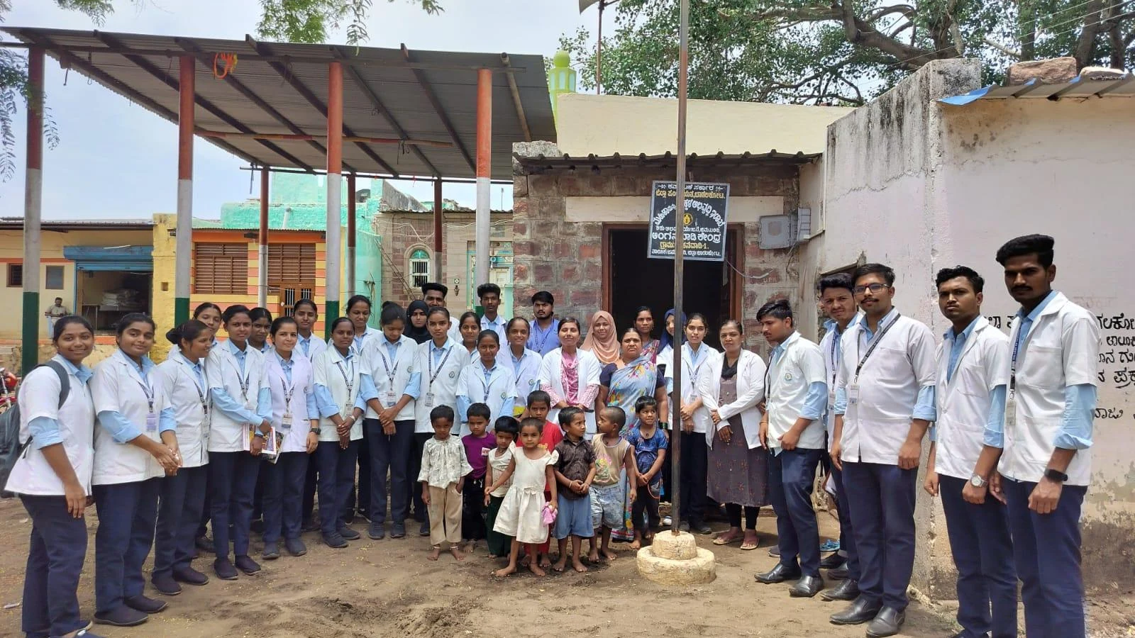 Seventh Semester BSc Nursing students BLDEA College of Nursing Jamkhandi group photo with Anganwadi worker and beneficiary children at Anganwadi Centre Kakanawadi with Anganwadi signboard visible 2 June 2026