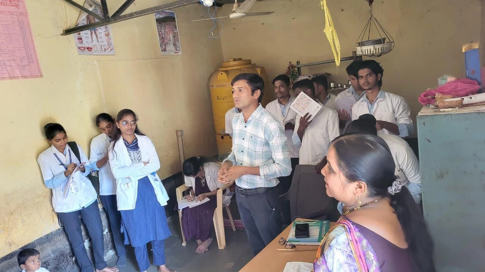 BLDEA College of Nursing Jamkhandi nursing students at Anganwadi Centre Kakanawadi interior observing records nutrition services baby weighing equipment and health registers during Community Health Nursing educational visit 2026