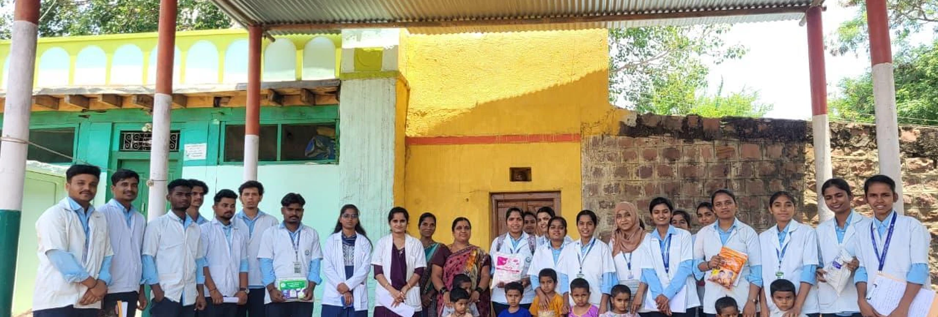 BSc Nursing Students BLDEA College of Nursing Jamkhandi group photo with Anganwadi worker and children at Anganwadi Centre Kakanawadi during Community Health Nursing educational visit June 2026