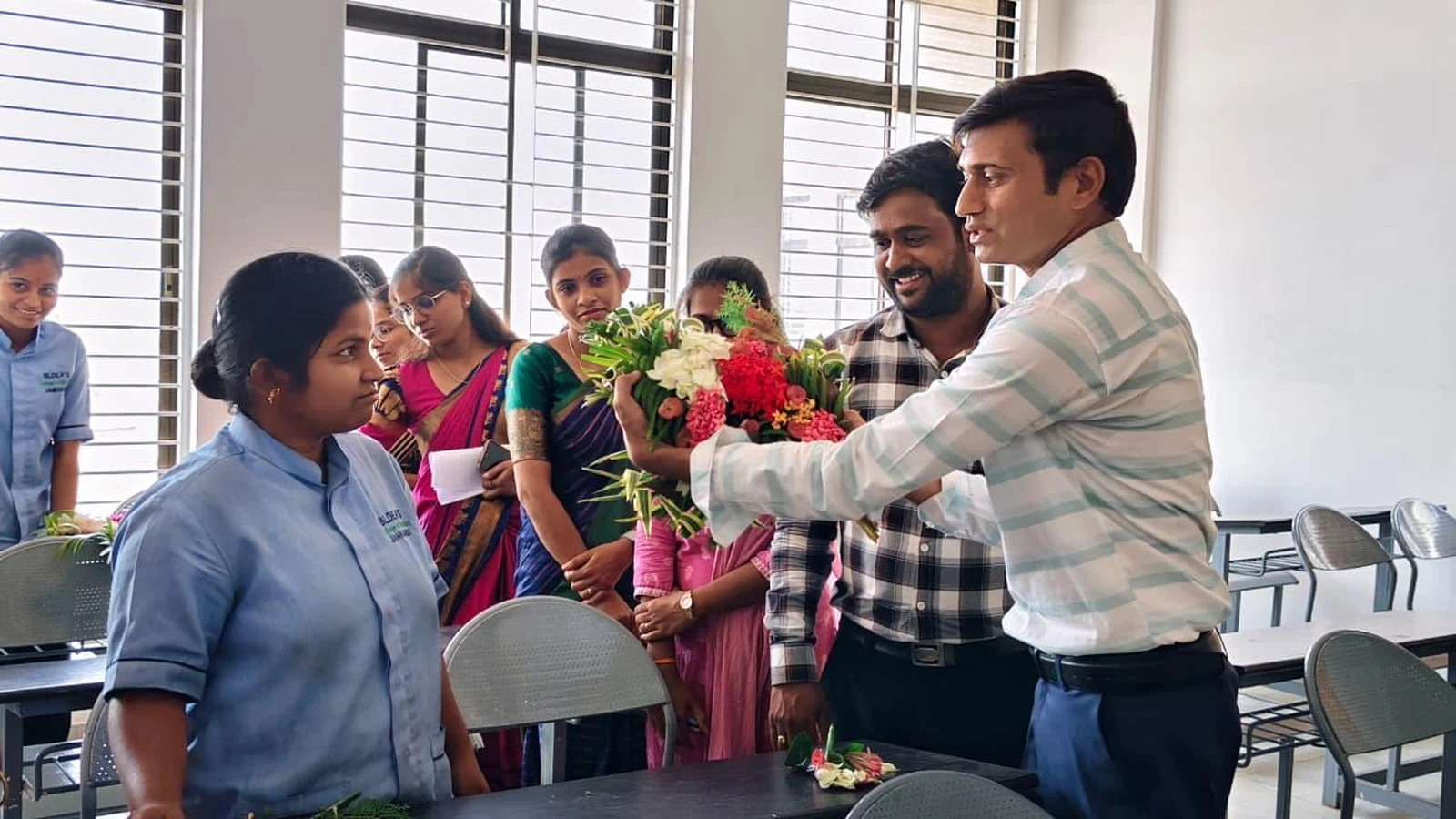 Judge reviewing a participant's bouquet at Intercollegiate Bouquet Making Competition 2026 – BLDEA College of Nursing Jamkhandi
