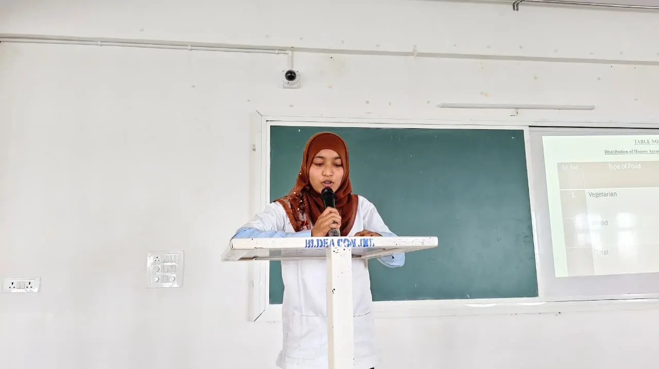Fifth Semester B Sc Nursing student presenting community health survey findings on stage Jamkhandi College of Nursing August 2026