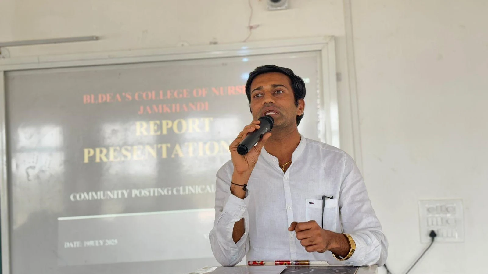 Dr Veerabhadrappa G Mendagudli Principal BLDEAS College of Nursing Jamkhandi or faculty member addressing and motivating students at Community Health Nursing Report Presentation for 15-day Mareguddi village CHN field posting July 19 2025 with Report Presentation Community Posting Clinical Experience screen behind