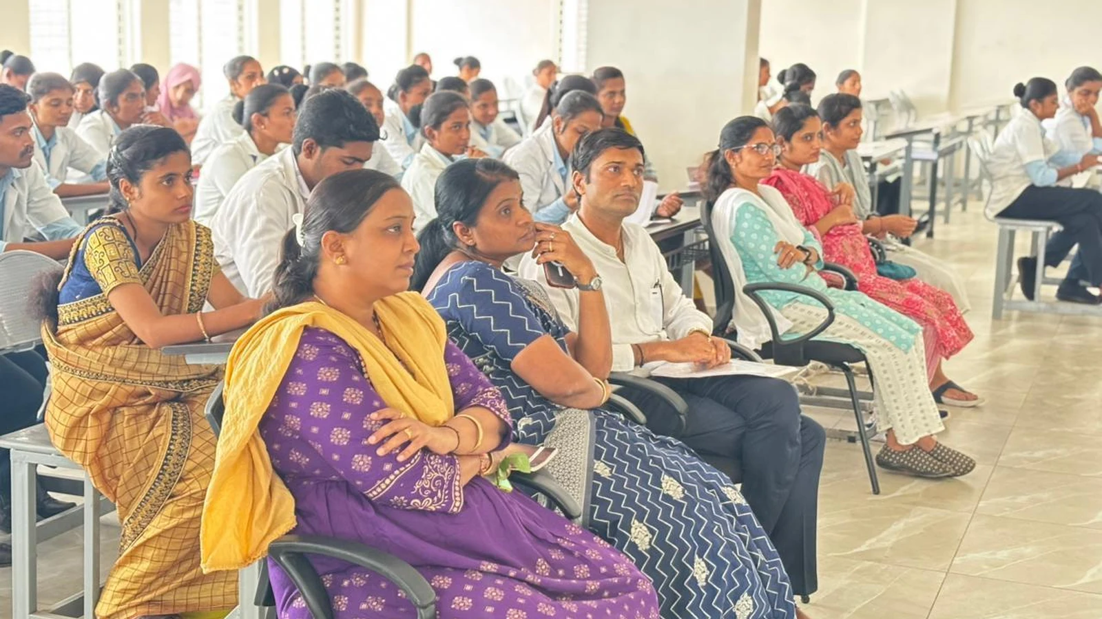 Wide view of students and faculty seated in seminar hall attending Community Health Nursing Report Presentation of Final Year and Fifth Semester BSc Nursing students who completed 15-day CHN clinical posting at Mareguddi village BLDEAS College of Nursing Jamkhandi July 19 2025