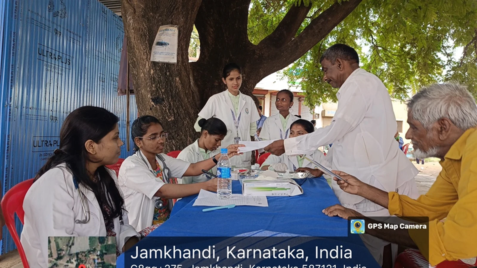 Nursing students of BLDEAS College of Nursing Jamkhandi registering villagers and handing out forms at outdoor desk under tree during free health check-up camp at Mareguddi village Karnataka August 1 2025