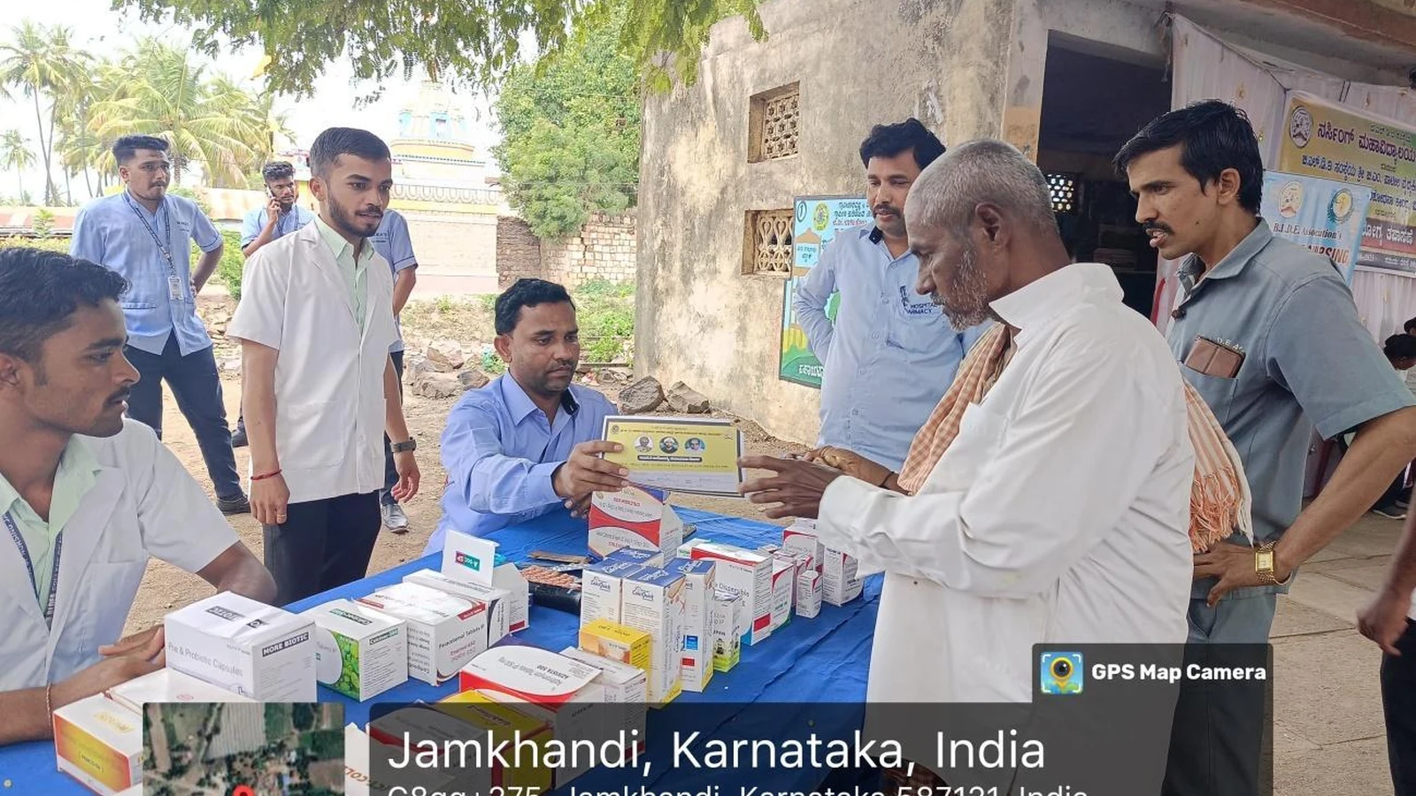 Medical students distributing free medicines from table stacked with medicine boxes to villagers during free health check-up camp organized by BLDEAS College of Nursing Jamkhandi at Mareguddi village Karnataka August 1 2025