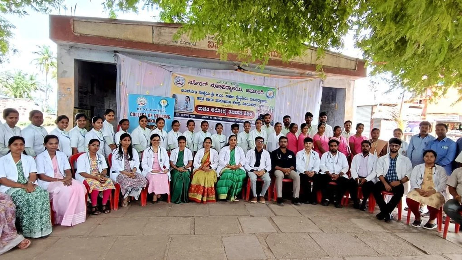 Group photo of nursing students doctors faculty and staff of BLDEAS College of Nursing Jamkhandi and Shri BM Patil Medical College Vijayapura who organized free health check-up camp at Mareguddi village Karnataka August 1 2025 in front of venue with camp banner