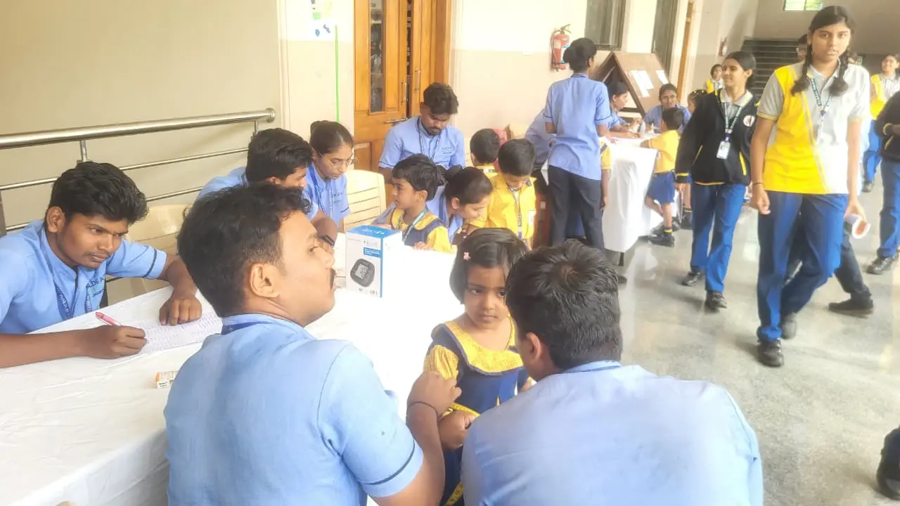 Fifth Semester B Sc Nursing student checking dental and nutritional status of school child during health camp BLDEA Public School Jamkhandi