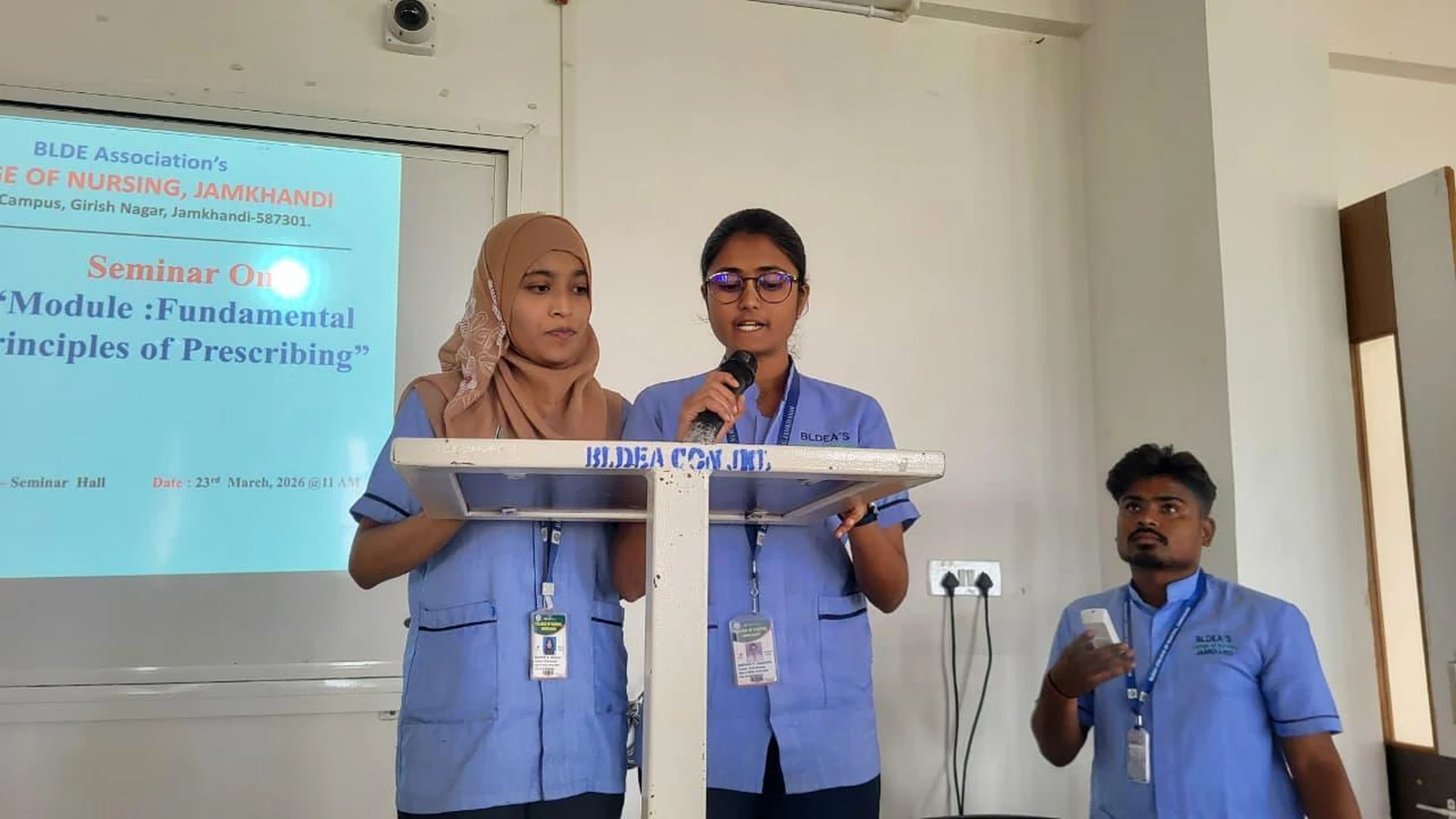Students delivering welcome address at BLDEA College of Nursing podium at Seminar on Fundamental Principles of Prescribing – Jamkhandi