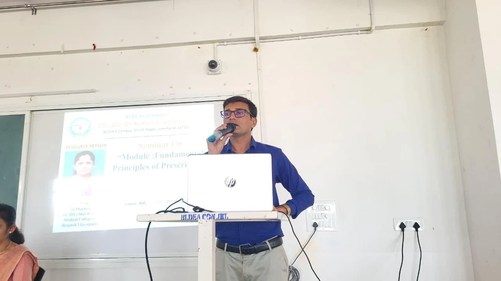 Faculty member addressing audience at BLDEA College of Nursing podium during Seminar on Fundamental Principles of Prescribing 2026 Jamkhandi