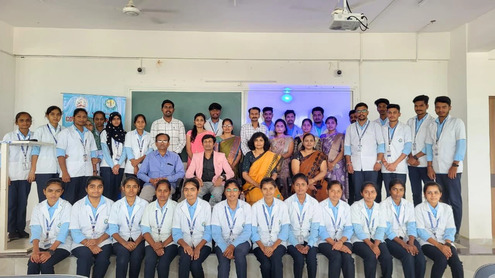 Group photograph of nursing students in blue uniforms Dr Sangam Hebballi and BLDEA College of Nursing Jamkhandi faculty at guest lecture on Blood Cancer Challenges Prevention and Nursing Responsibilities October 15 2025