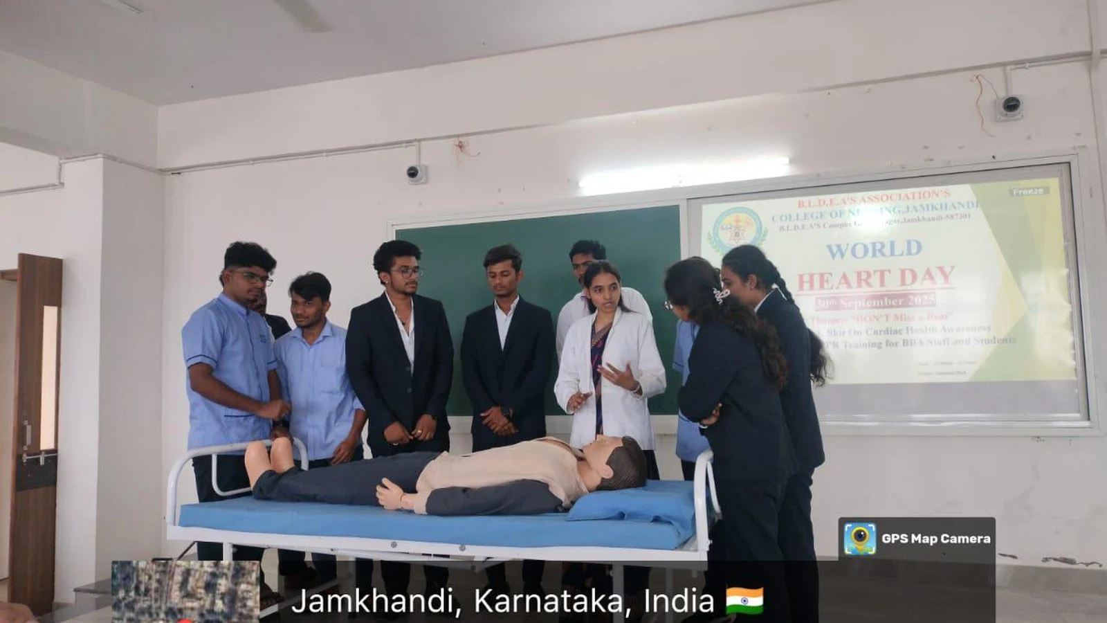 Nursing students Ms Ankita M Ms Deepa V and Mr Deeraj from BLDEAS College of Nursing Jamkhandi demonstrating CPR on mannequin to BBA staff and students during World Heart Day 2025 CPR training session with World Heart Day projector screen in background September 30 2025