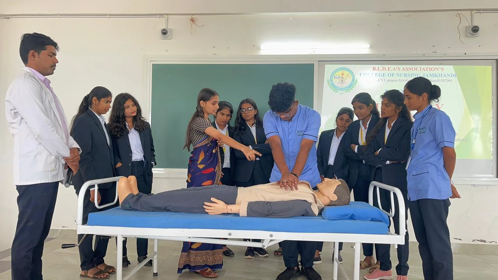 BBA student performing return CPR demonstration on mannequin while nursing students from BLDEAS College of Nursing Jamkhandi supervise and guide during World Heart Day 2025 CPR training September 30 2025