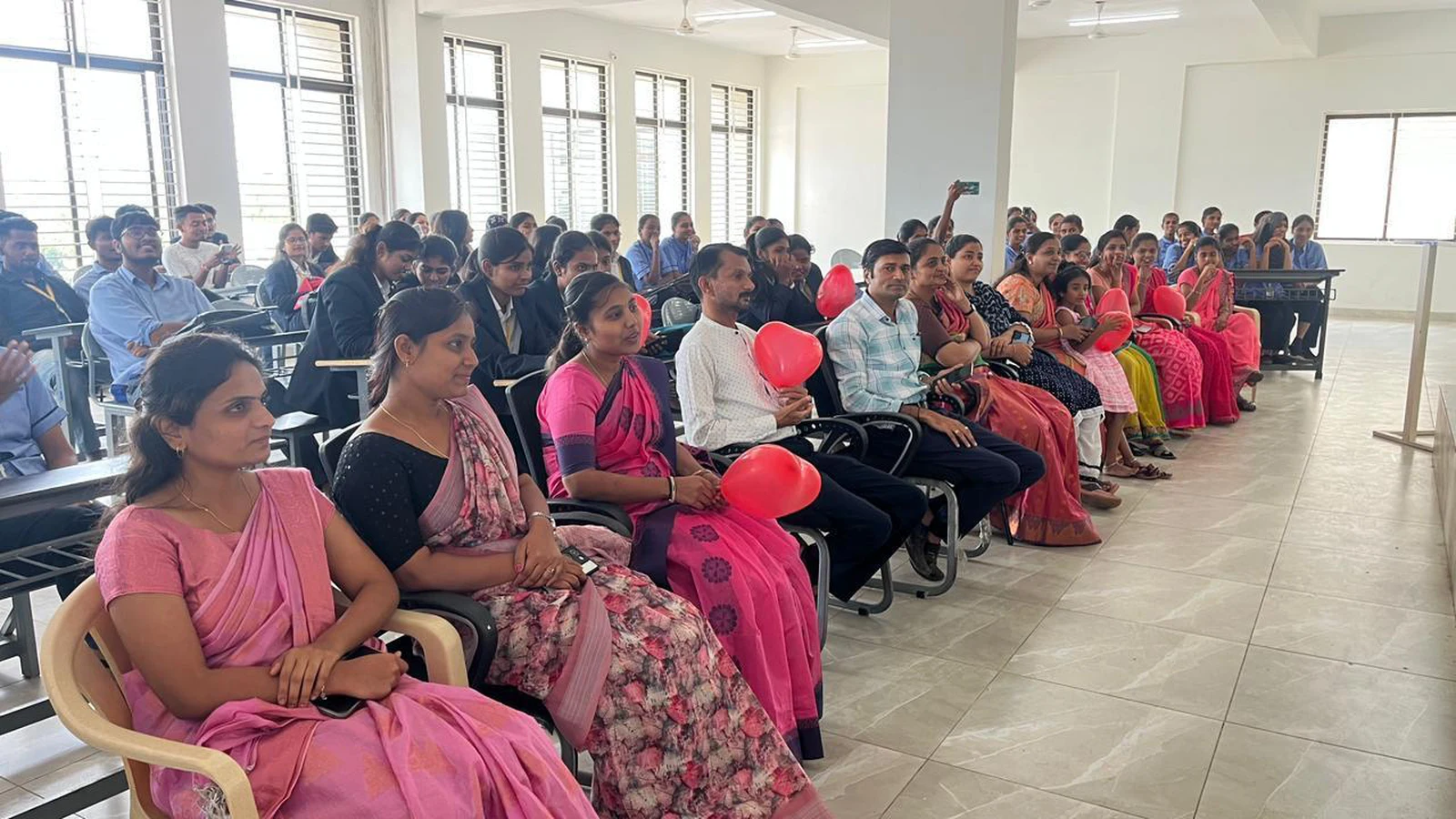 Participants seated with red heart balloons at hands-on CPR training for World Heart Day 2025 organized by BLDEAS College of Nursing Jamkhandi at BLDE BBA Seminar Hall September 30 2025