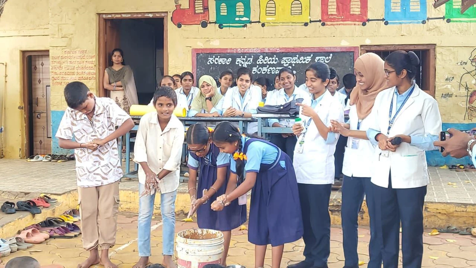 School children performing handwashing return demonstration supervised by BLDEA College of Nursing Jamkhandi Seventh Semester BSc Nursing students at Government Primary School Kakanwadi Village during Health Education Programme June 2026