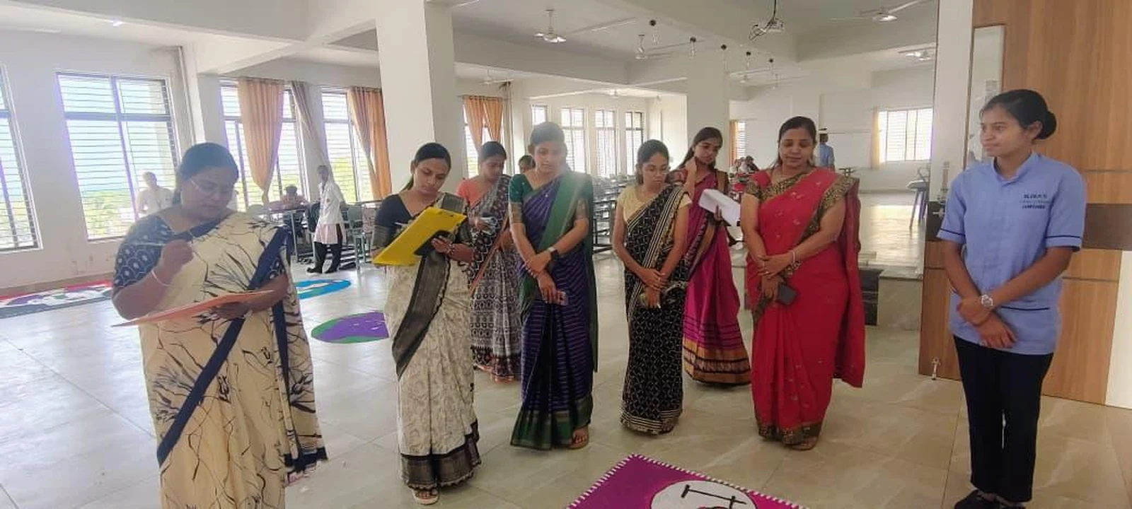 Judges evaluating rangoli entries and participants at Intercollegiate Rangoli Competition 2026 – BLDEA College of Nursing Jamkhandi