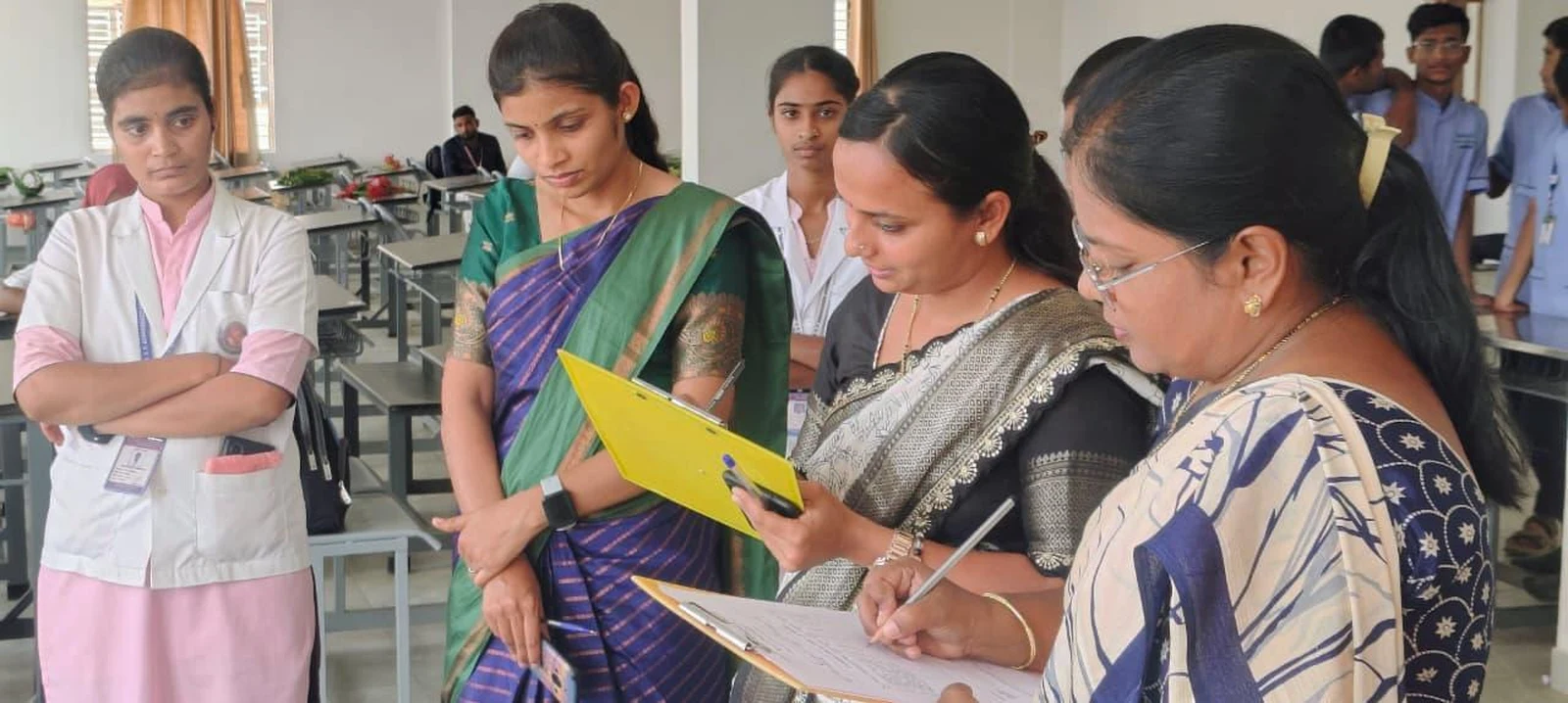Mrs. Poornima Surpur and Mrs. Ashwini Ananthpur scoring entries at Intercollegiate Rangoli Competition 2026 – BLDEA College of Nursing Jamkhandi