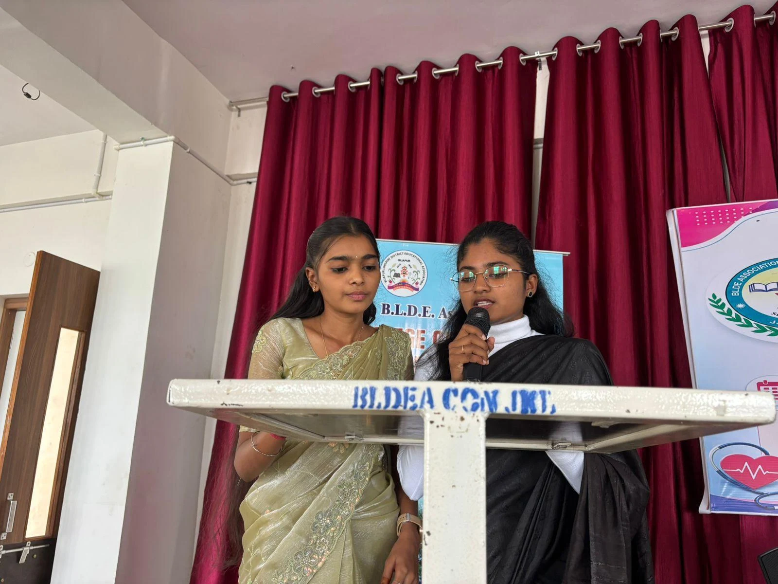 MC students Ms. Vandhana Chikkaraddi and Ms. Varsha conducting the programme – International Nurses Day 2026, BLDEA College of Nursing Jamkhandi