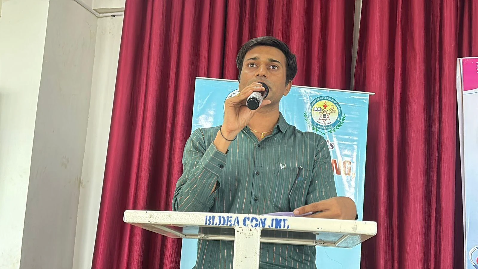 Faculty address at podium – International Nurses Day 2026, BLDEA College of Nursing Jamkhandi