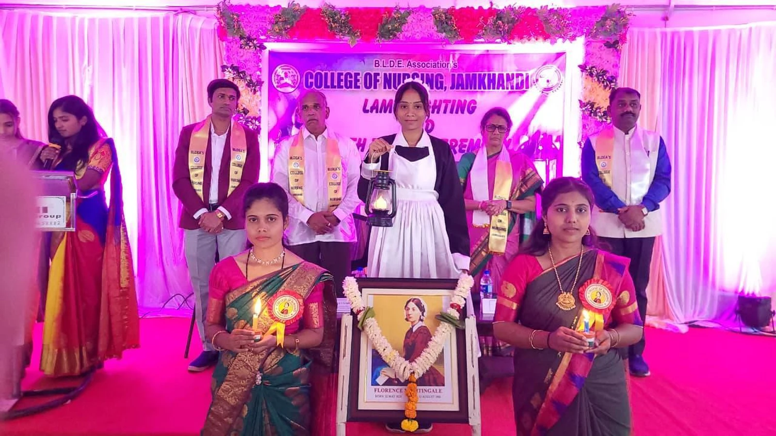 Lamp Lighting Ceremony stage with students and Florence Nightingale portrait at BLDEA College of Nursing Jamkhandi Oath Taking Ceremony 2026 5th Batch