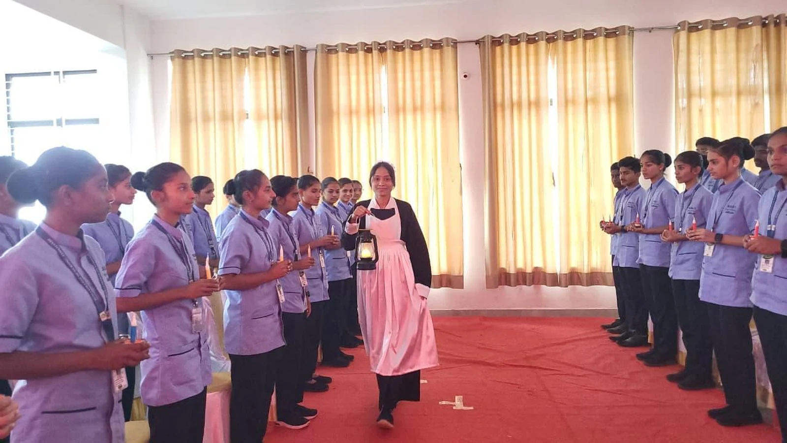 Student in Florence Nightingale costume leading Oath Taking Ceremony procession at BLDEA College of Nursing Jamkhandi 2026 5th Batch
