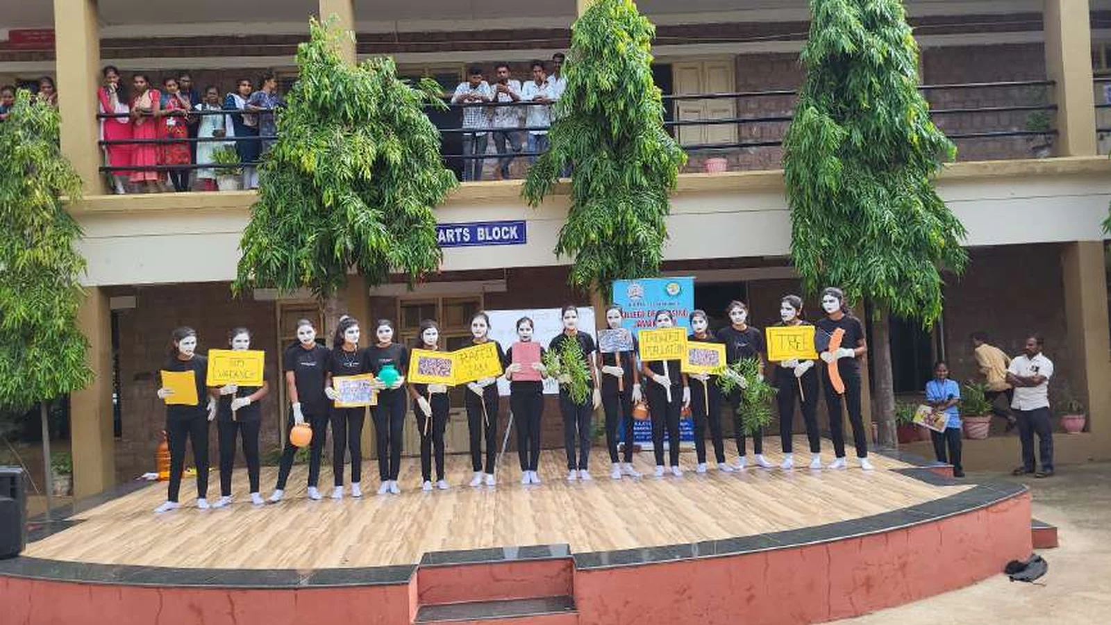 Sixteen second semester BSc Nursing students of BLDEAS College of Nursing Jamkhandi standing in a row on stage holding yellow awareness placards during World Population Day 2024 mime show at college campus Jamkhandi July 11 2024