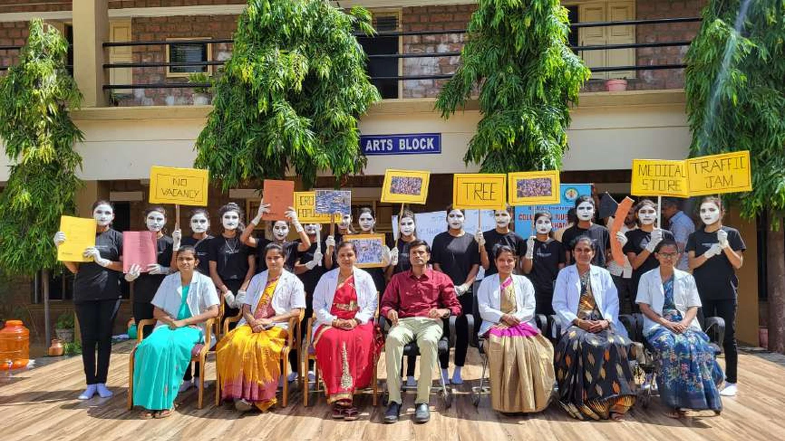 Group photo of second semester BSc Nursing students holding World Population Day 2024 awareness placards with messages NO VACANCY TREE MEDICAL STORE TRAFFIC JAM with dignitaries including Dr Veerabhadrappa G Mendagudli Principal BLDEAS College of Nursing and Prof BI Karalatti Principal Independent PU College seated in front after mime show at college campus Jamkhandi July 11 2024