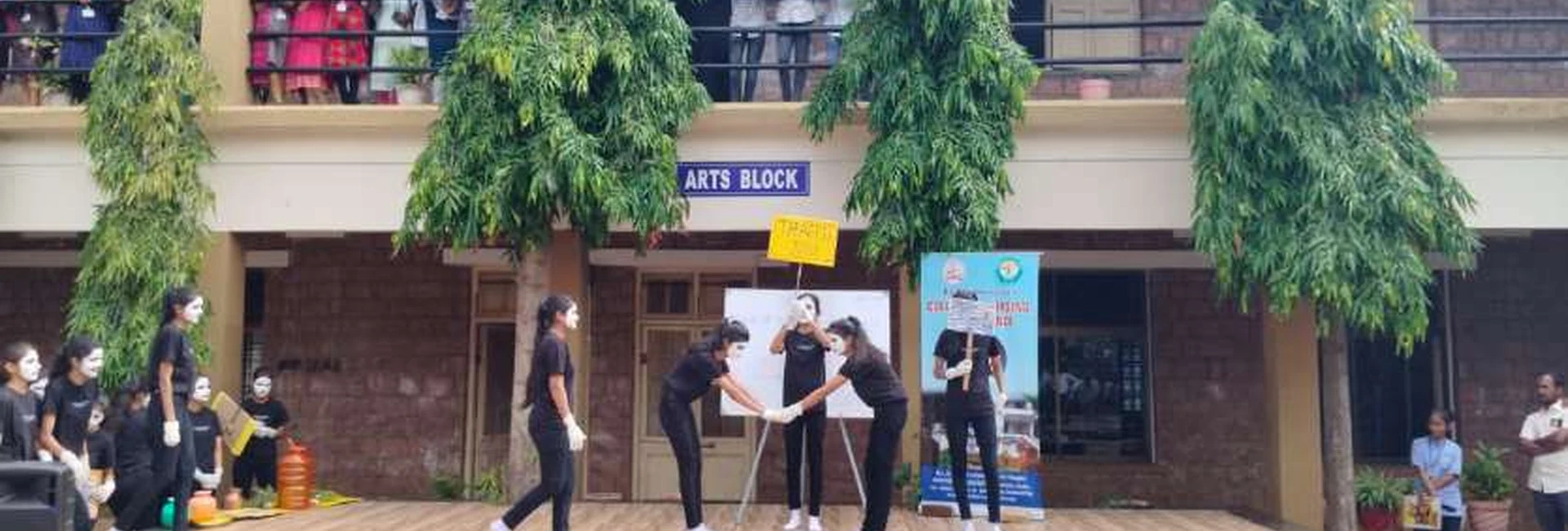 Second semester BSc Nursing students from BLDEAS College of Nursing Jamkhandi performing World Population Day 2024 mime show on outdoor stage at college campus Jamkhandi with Arts Block building and audience watching July 11 2024