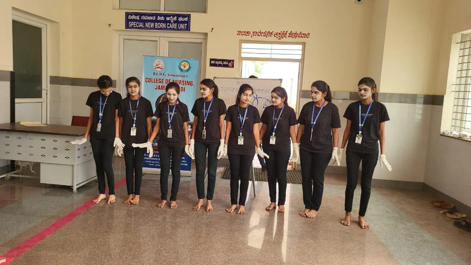 Group of third semester BSc Nursing students in black outfits performing tuberculosis awareness mime at OPD of Taluka Hospital Jamkhandi during World Tuberculosis Day 2025 program organized by BLDEAS College of Nursing Jamkhandi