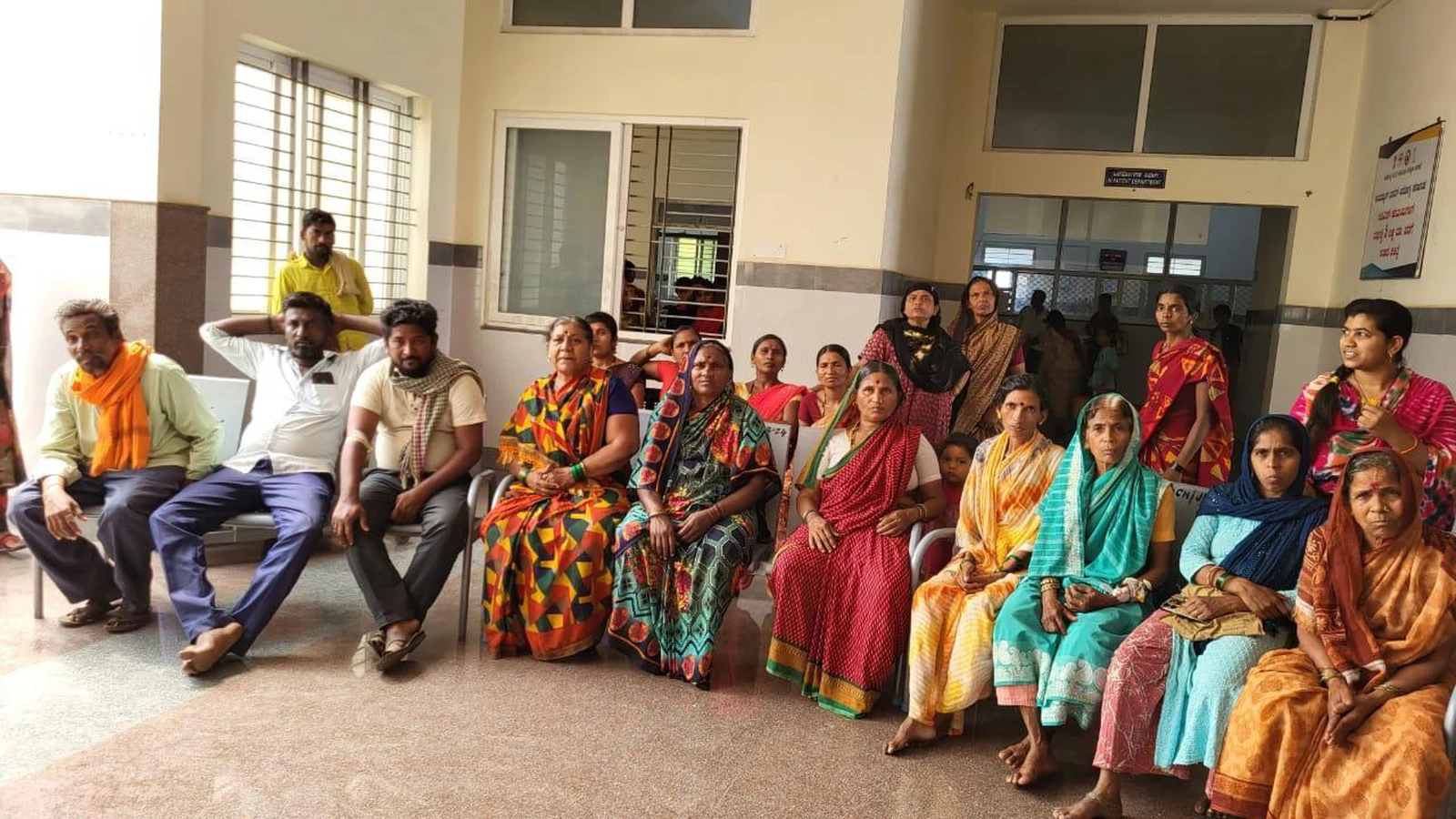 Patients and their relatives seated in OPD waiting area of Taluka Hospital Jamkhandi watching World Tuberculosis Day 2025 awareness mime performed by BSc Nursing students BLDEAS College of Nursing Jamkhandi March 25 2025