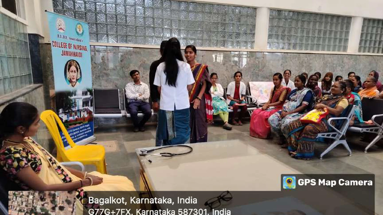 First semester BSc Nursing student in yellow saree performing girl child awareness skit at Tungal Hospital Jamkhandi with BLDEAS College of Nursing Jamkhandi rollup banner and mothers seated as audience National Girl Child Day January 24 2024