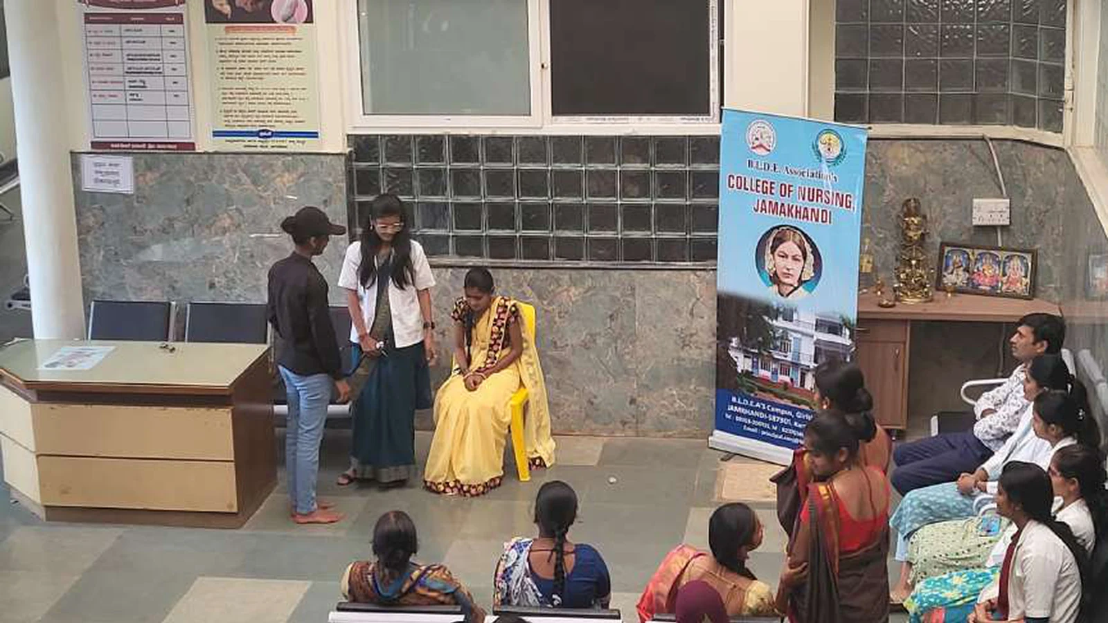 First semester BSc Nursing students performing National Girl Child Day awareness skit with BLDEAS College of Nursing Jamkhandi banner and ANC PNC mothers as seated audience at Tungal Hospital Jamkhandi January 24 2024