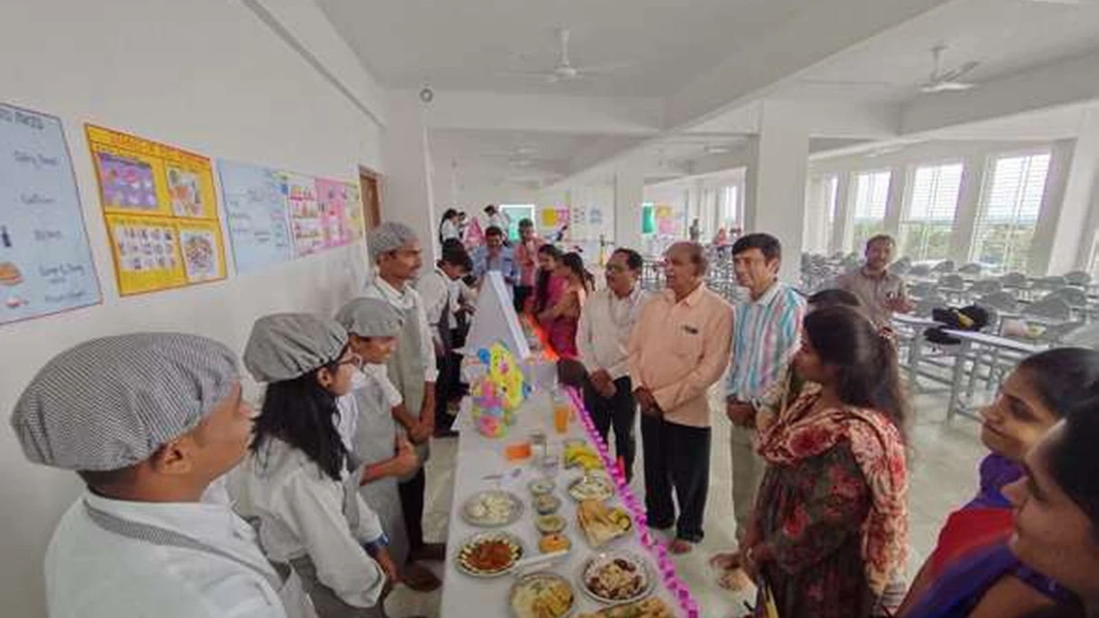 Prof SH Lagali Administrative Officer BLDE Association Jamkhandi and other faculty dignitaries evaluating a student diet exhibition stall with second semester BSc Nursing students of BLDEAs College of Nursing Jamkhandi in checker aprons presenting their diet plan and food display during judging session at Nutrition Exhibition and Demonstration Programme 2024 at Nutrition Lab BLDEAs College of Nursing Jamkhandi September 11 2024