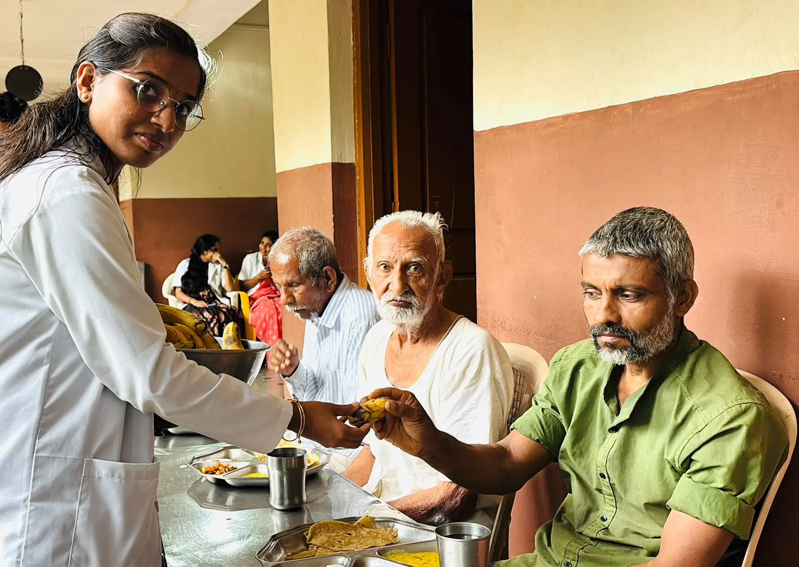 Nursing students singing and interacting with elderly residents during recreational activity at Jain Vrudhrashram Jamkhandi