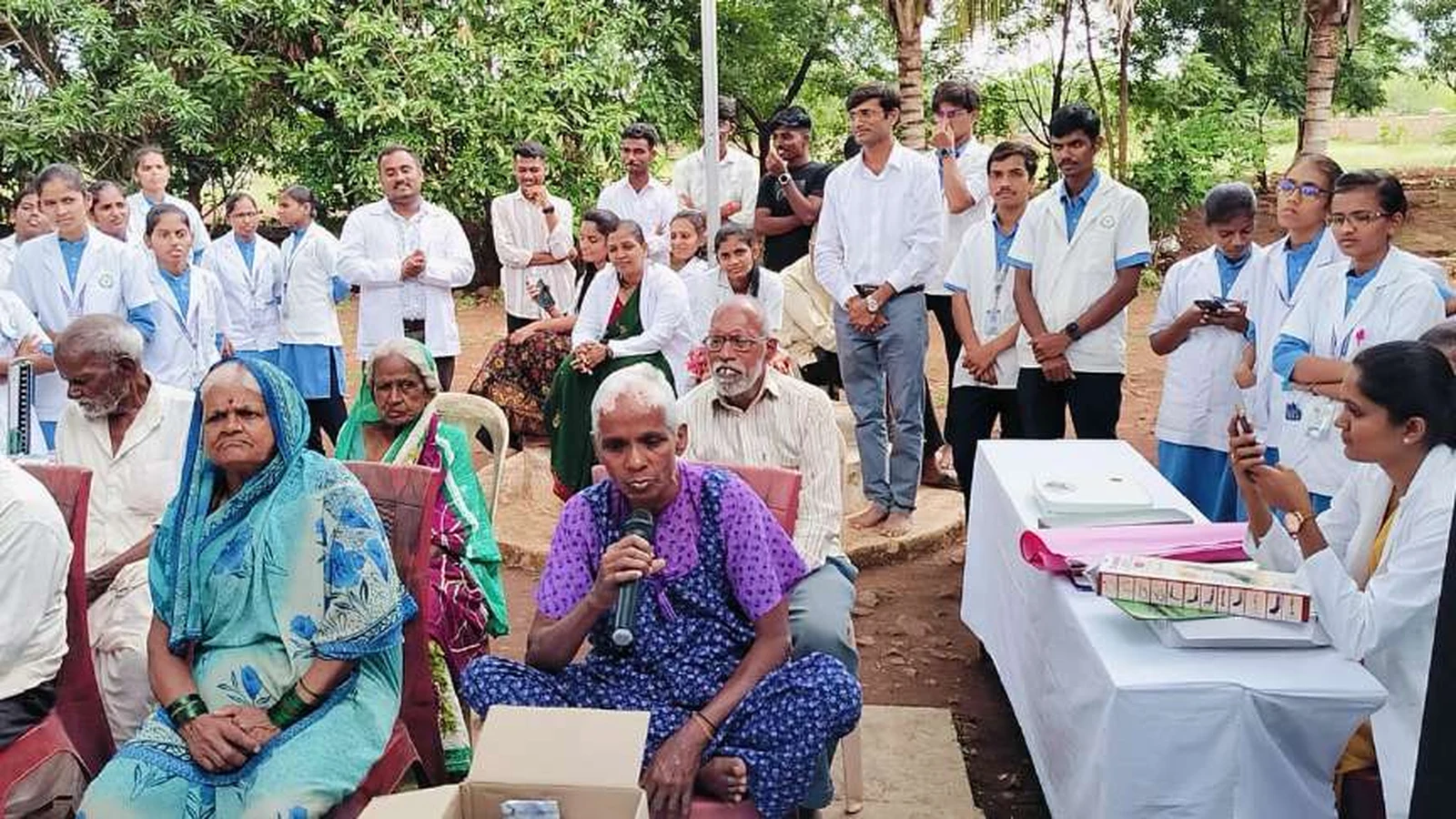 Elderly resident of Jain Vrudhrashram Jamkhandi joyfully joining the cultural program by singing at the microphone during visit by BLDEAS College of Nursing Jamkhandi third year BSc Nursing students July 18 2024