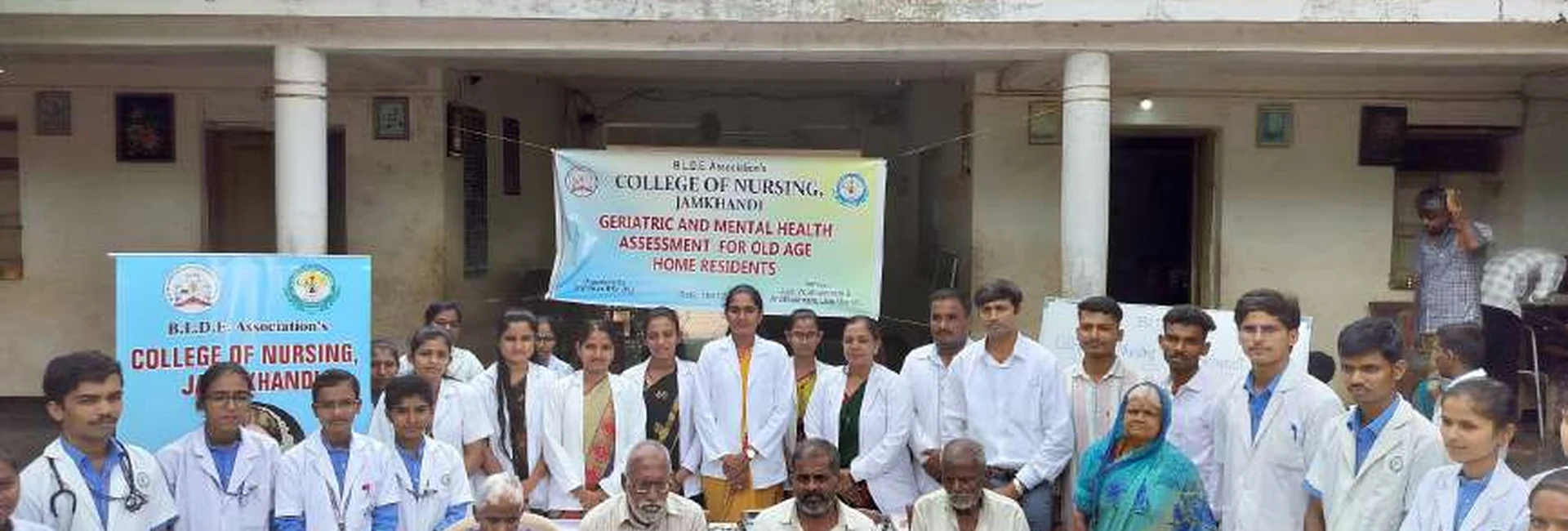 Third year BSc Nursing students of BLDEAS College of Nursing Jamkhandi at Jain Vrudhrashram Jamkhandi during geriatric and mental health assessment for old age home residents July 18 2024 with BLDEAS banner and students in white coats