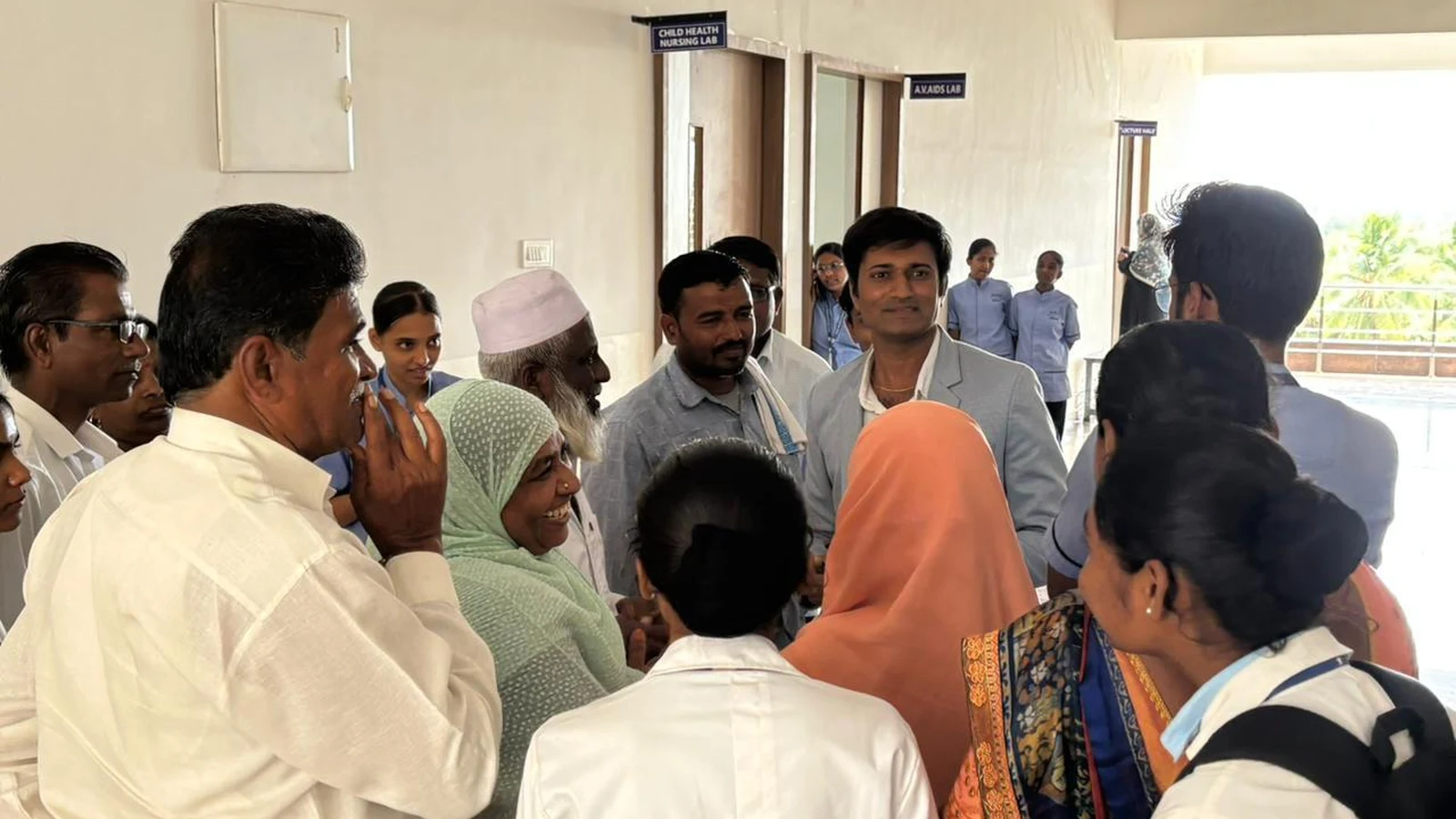 Faculty coordinator and nursing students engaging with parents in college corridor near nursing lab at BLDEA College of Nursing Jamkhandi during Parent-Teacher Meeting June 2026