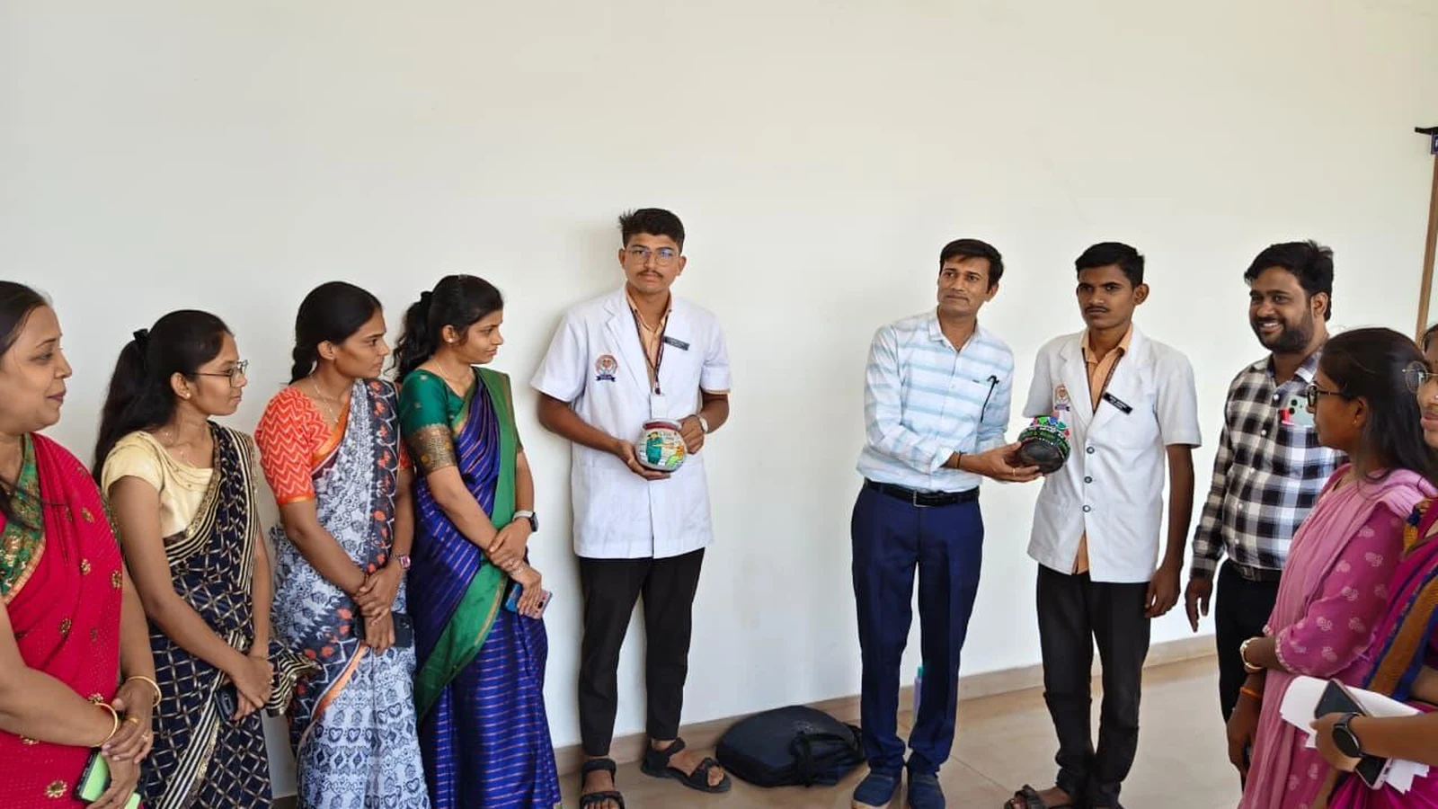 Students holding decorated painted pots at Intercollegiate Pot Painting Competition 2026 – BLDEA College of Nursing Jamkhandi