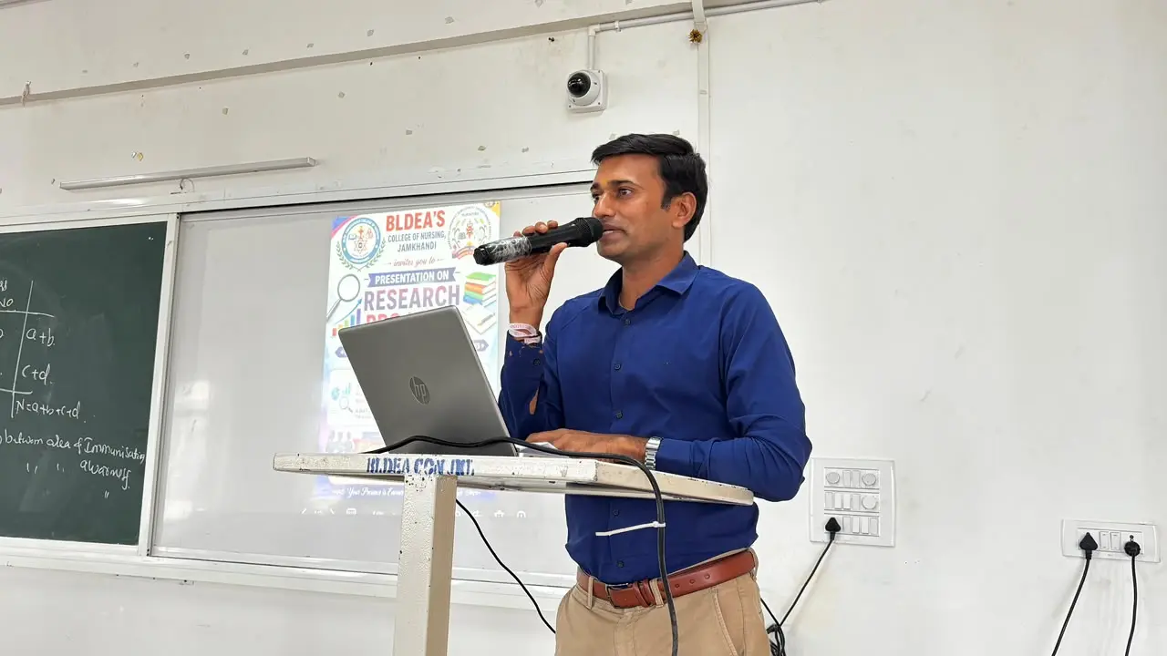 Eighth Semester B Sc Nursing student presenting research problem statement on stage BLDEA College of Nursing Jamkhandi