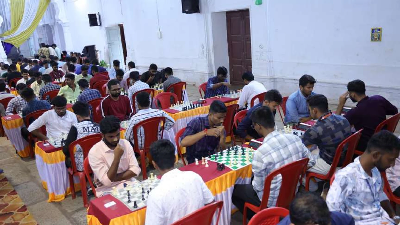Male chess players from health sciences colleges affiliated with RGUHS Kalaburagi Zone competing at chess boards during RGUHS Kalaburagi Zone Chess Men Tournament 2024 hosted by BLDEAS College of Nursing Jamkhandi at Darbar Hall BLDEA Campus August 23 24 2024
