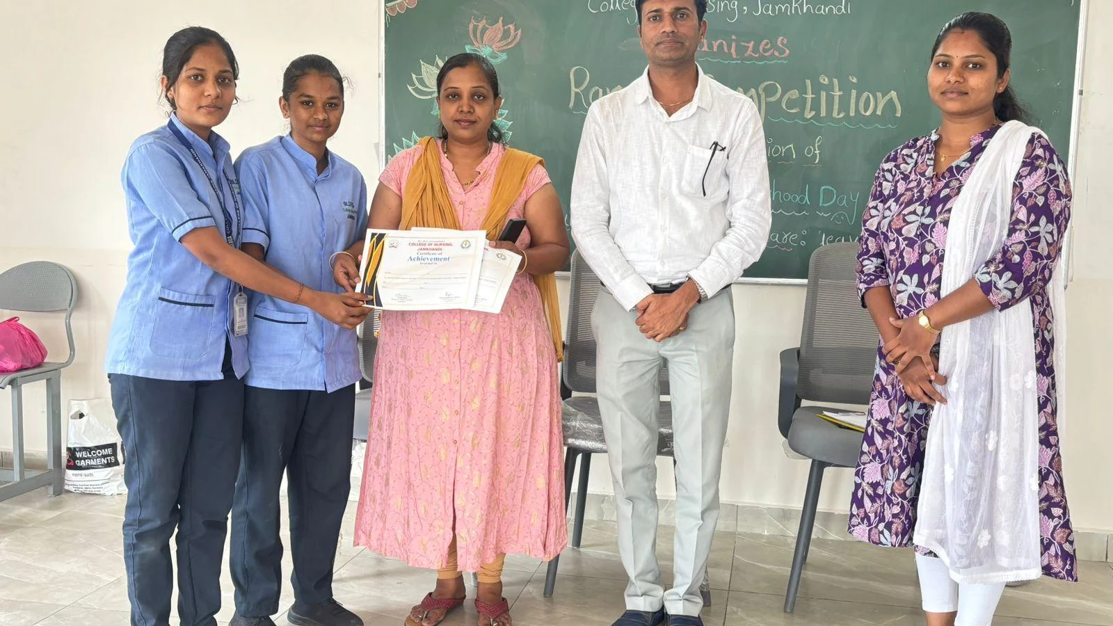 Certificate presentation at National Safe Motherhood Day Rangoli Competition 2026 – BLDEA College of Nursing Jamkhandi