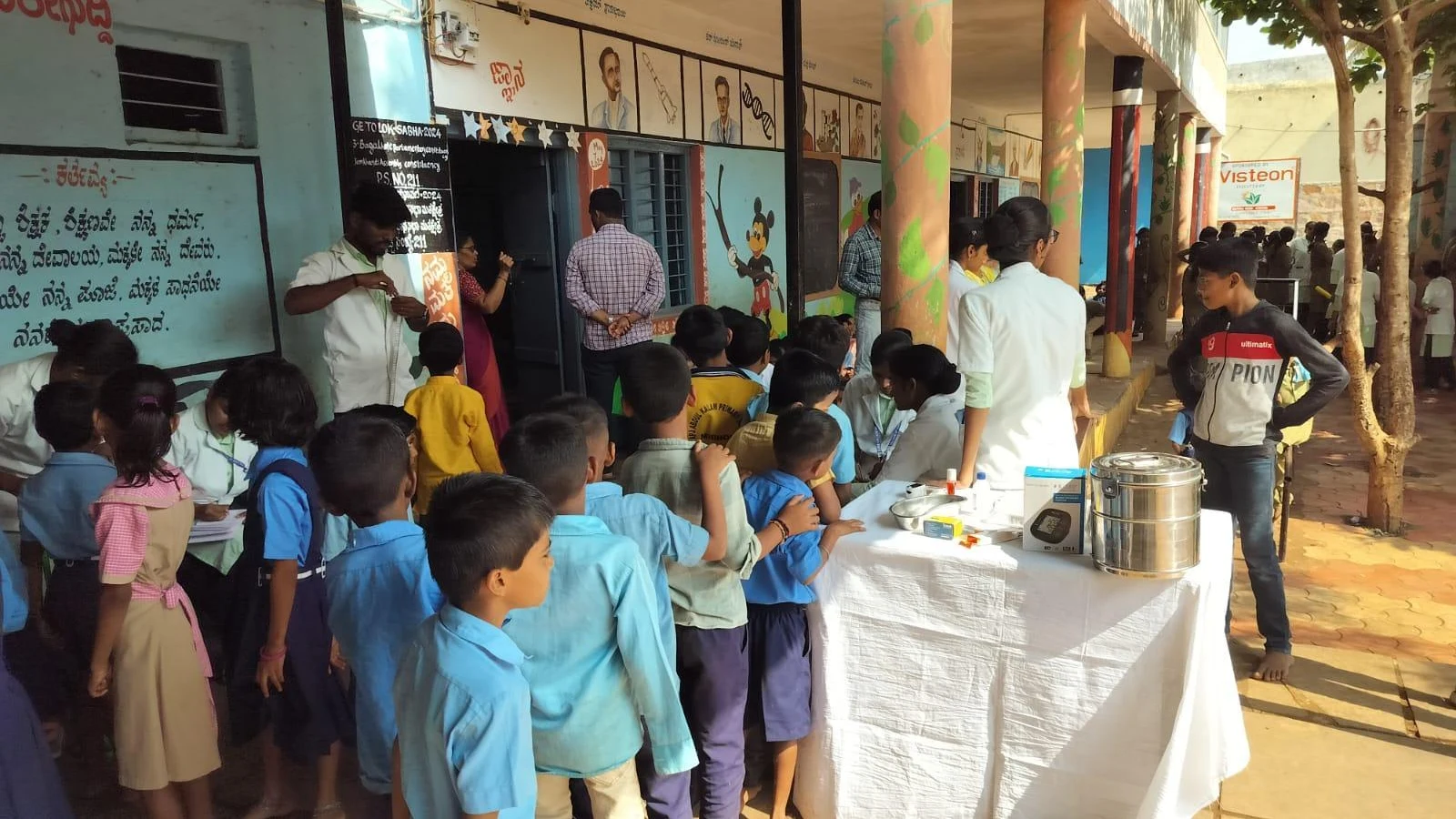 School children queued outdoors at weighing station during School Health Program at Government Primary School Mareguddi organized by final year BSc Nursing students BLDEAS College of Nursing Jamkhandi June 13 2025