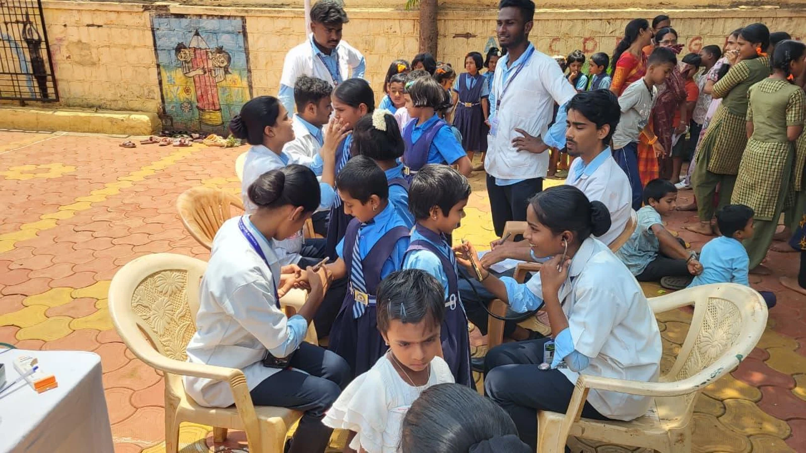 Fifth Semester BSc Nursing students BLDEA College of Nursing Jamkhandi conducting health screening and clinical examination for school children in courtyard at Government Primary School Kakanwadi School Health Programme June 2026