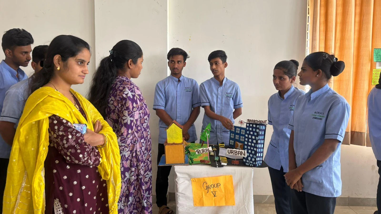 Group V students presenting Urban and Rural Community Dynamics model at Sociology Psychology Exhibition – BLDEA College of Nursing Jamkhandi