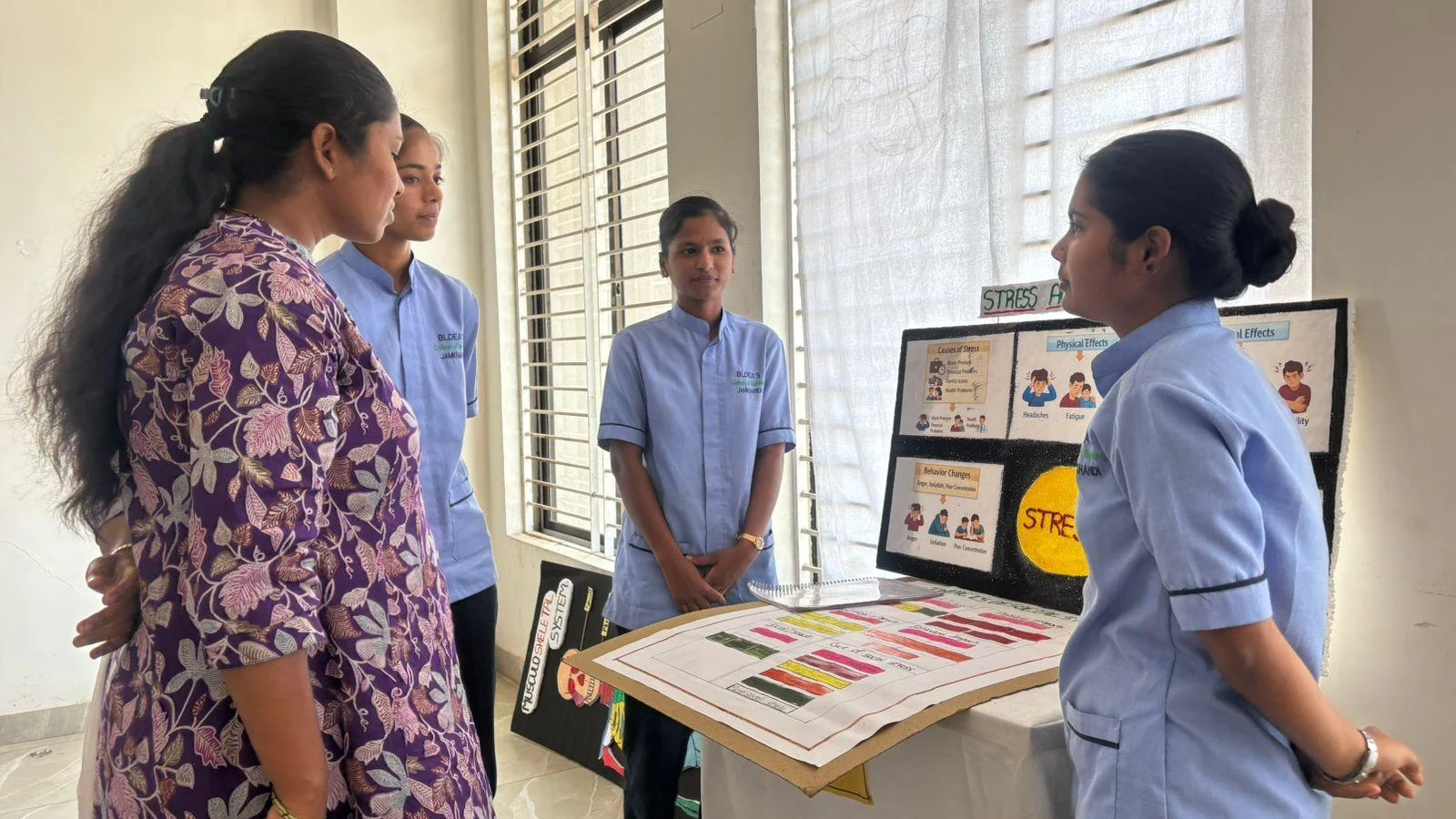 Faculty evaluating student presentation on Stress at Sociology Psychology Model Exhibition – BLDEA College of Nursing Jamkhandi