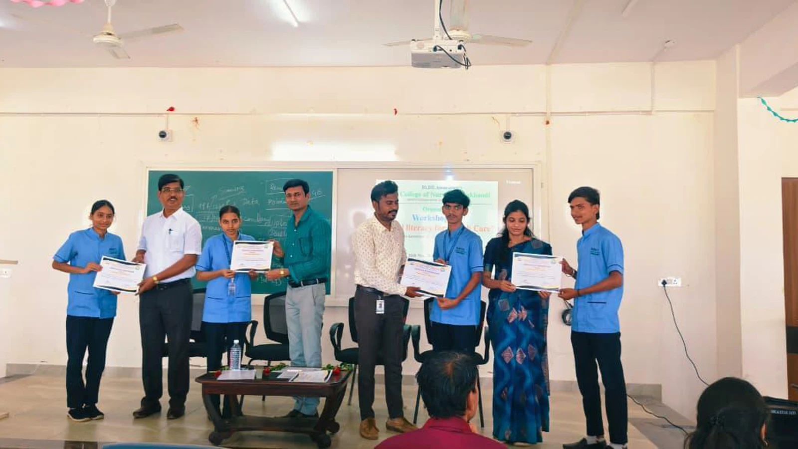 Group of Second Semester BSc Nursing students and faculty standing on stage holding participation certificates at valedictory session of Workshop on Digital Literacy for Health Care BLDEA College of Nursing Jamkhandi November 10 2025
