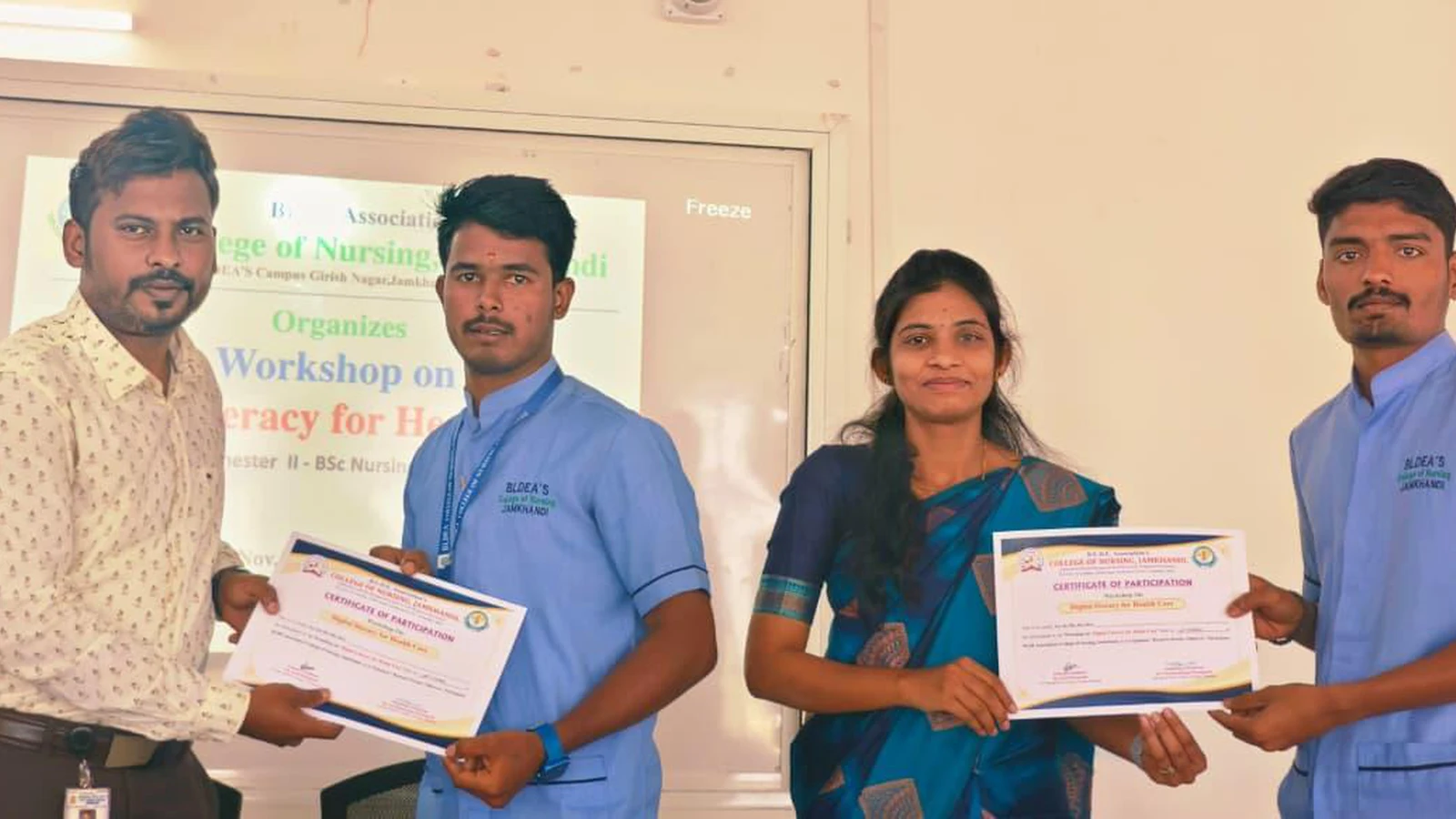 Faculty member distributing participation certificate to Second Semester BSc Nursing students in front of Workshop on Digital Literacy for Health Care poster at BLDEA College of Nursing Jamkhandi November 10 2025